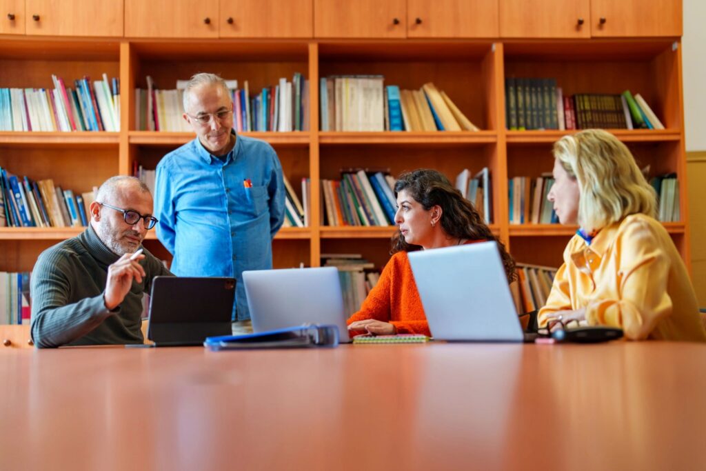 A group of business people are using mobile devices in a meeting room.